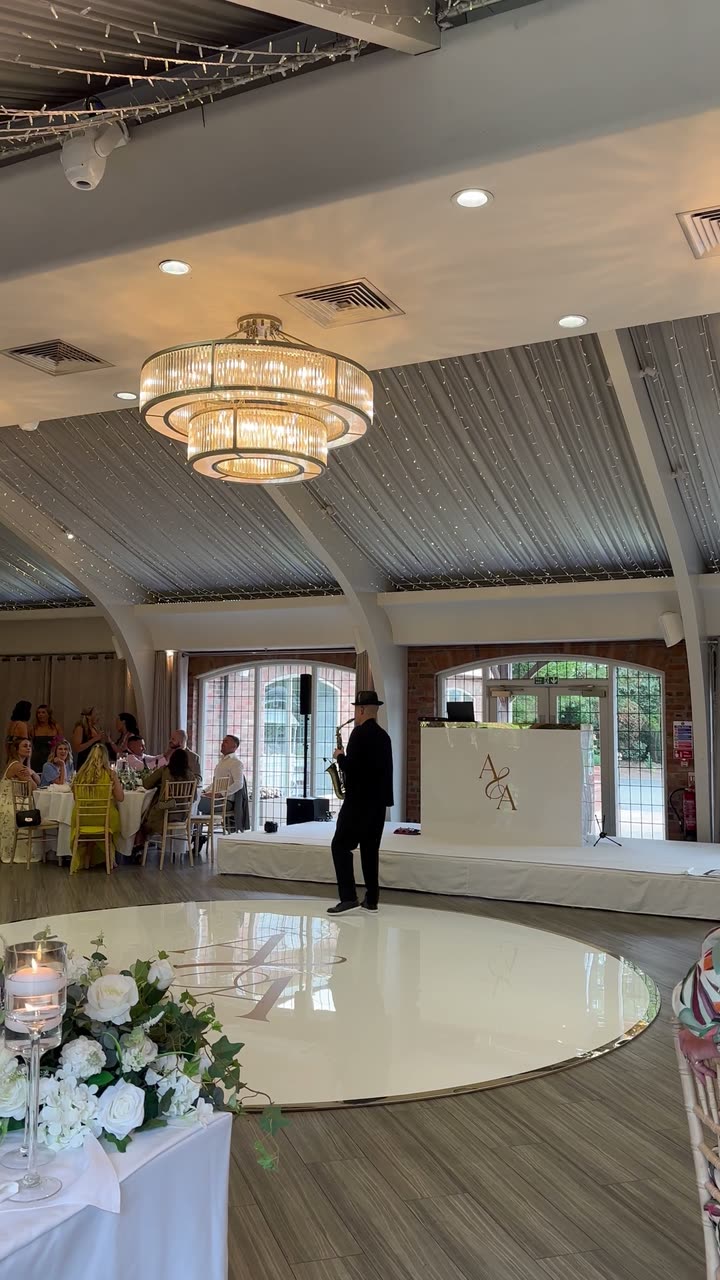 A saxophonist performing beside a white dancefloor
