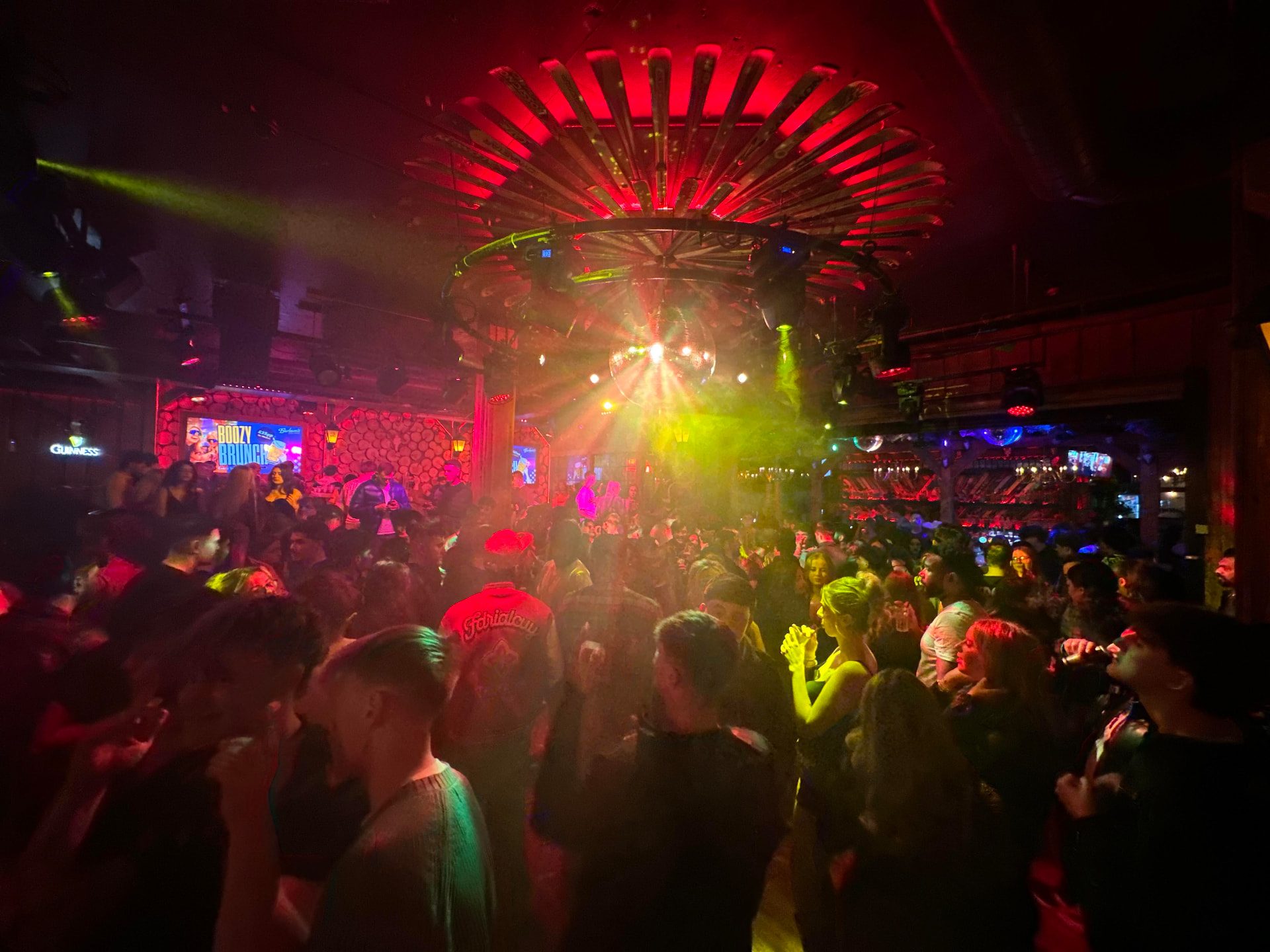 A packed nightclub dancefloor in red light