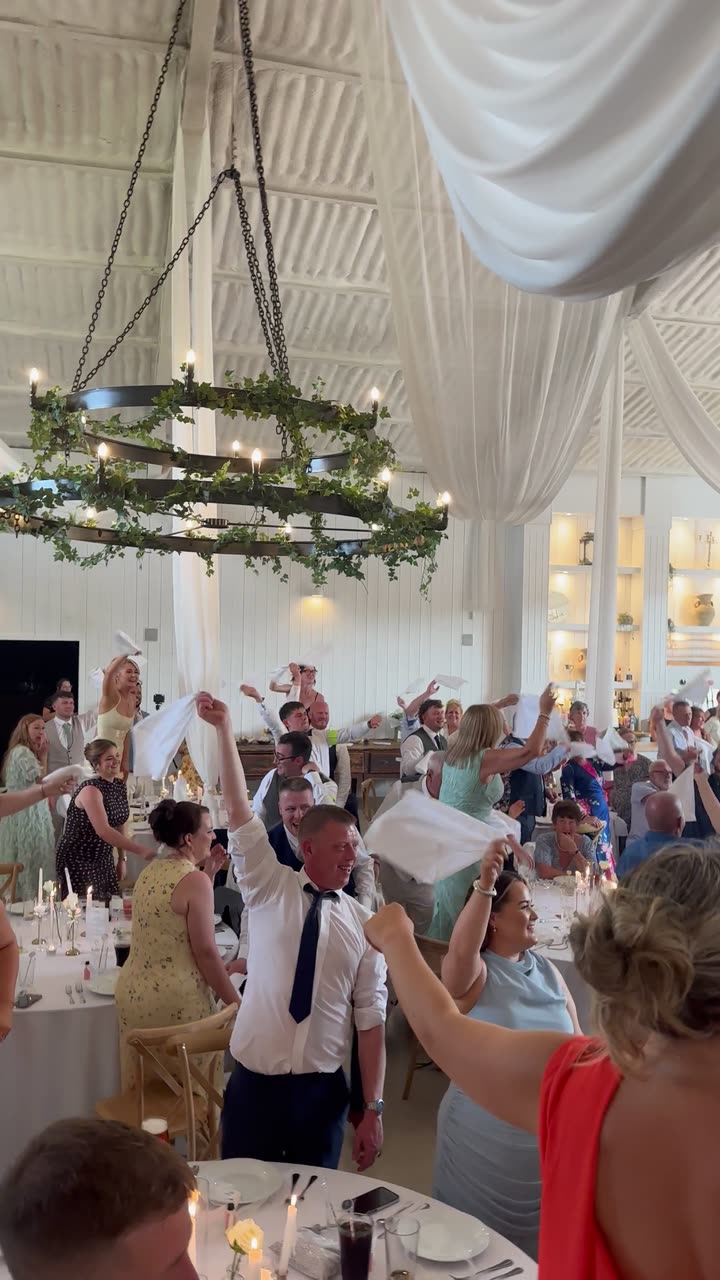 Guests waving napkins at a wedding breakfast