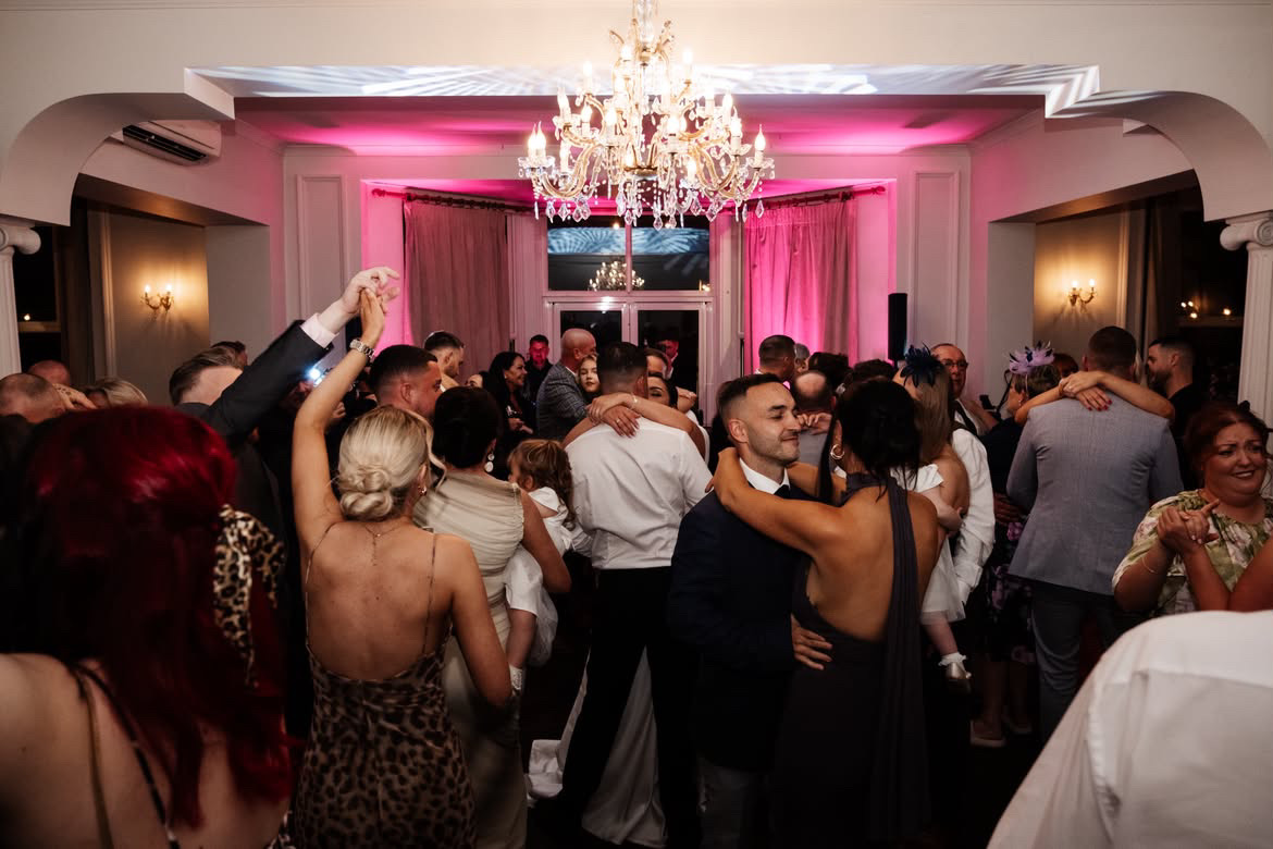 A packed dancefloor beneath the chandelier